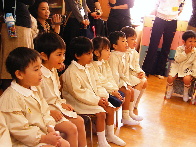 young japanese students in white watching performance