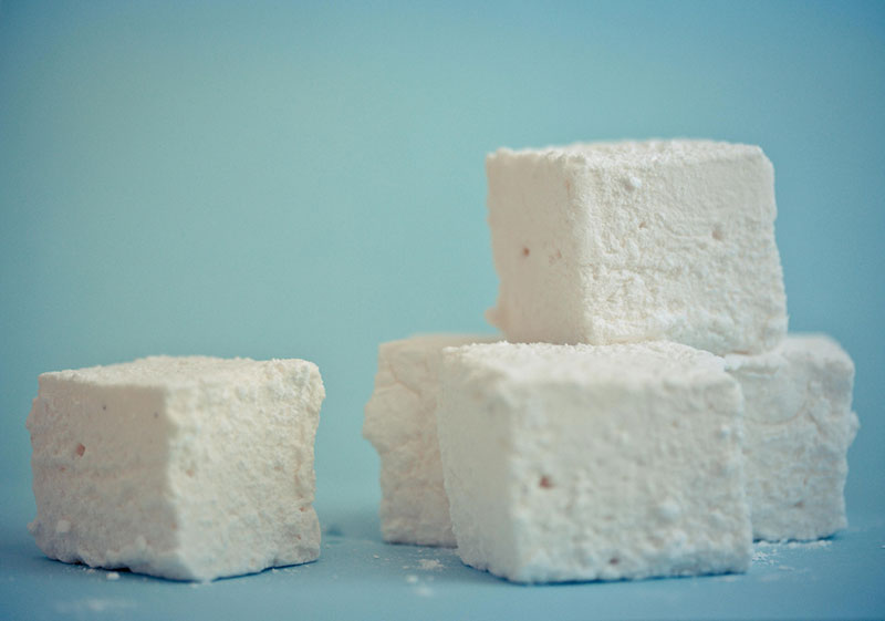 four white marshmallows on a blue background