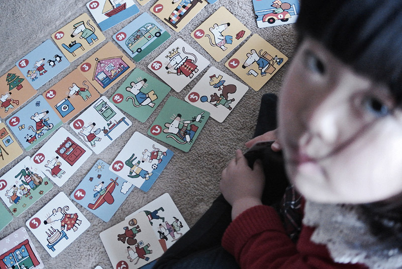 girl in front of cards on the floor