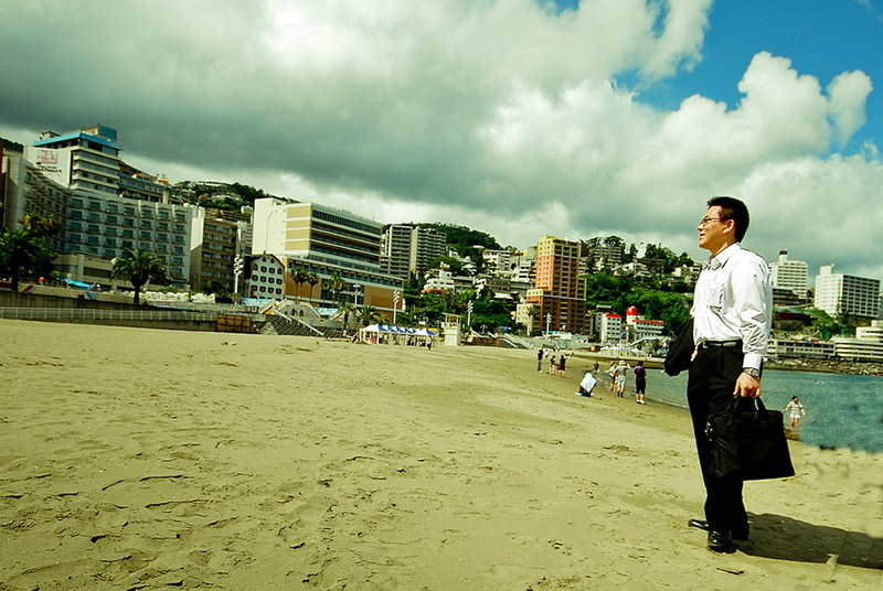 asian salaryman with taijin kyofusho standing on a beach