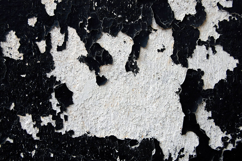 Black paint chipping off a wall