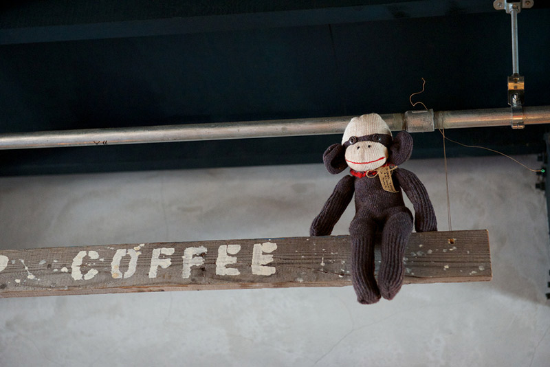 stuffed monkey perched on coffee sign