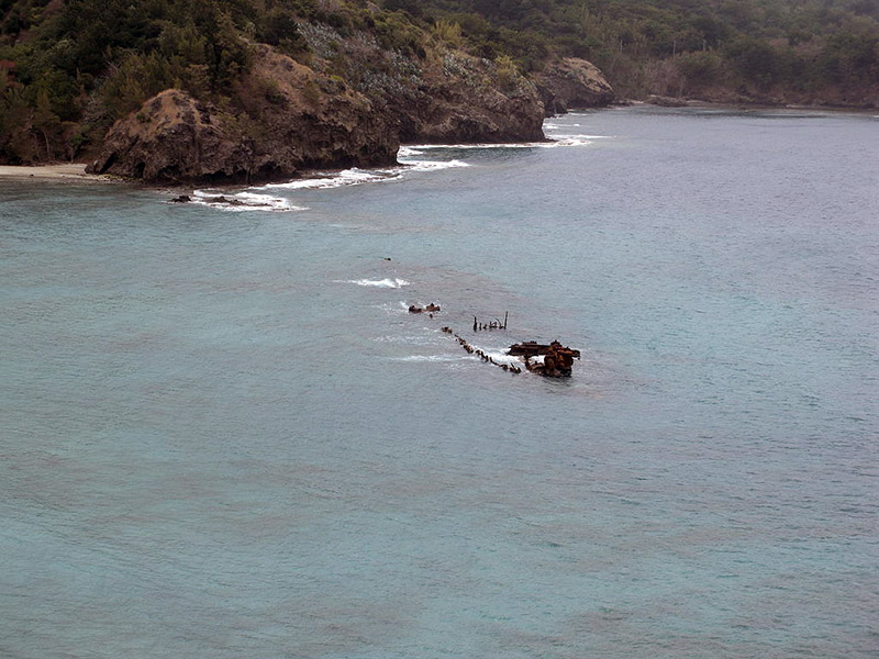 The rusted top of a ship poking through the ocean’s surface