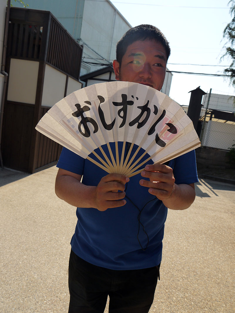 man holding a fan that says quiet please in japanese