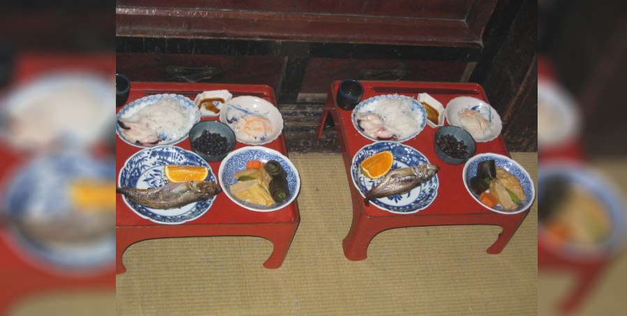 Bowls and plates with fish and other food on red lacquer trays