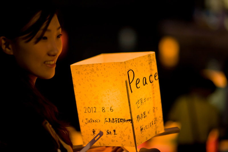 japanese woman holding a lantern that says peace