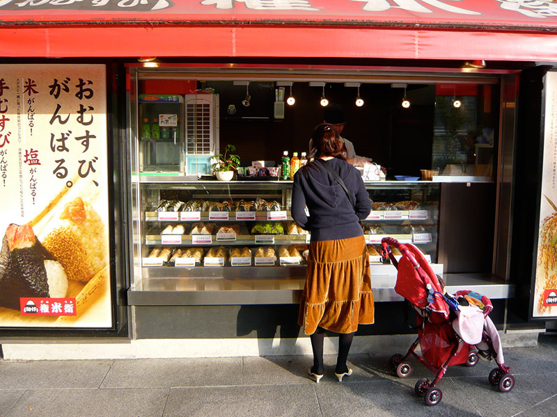 woman standing outside japanese food onigiri stand