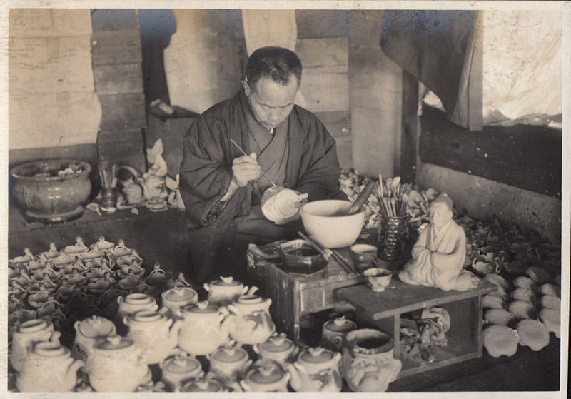 black and white japanese man painting pottery