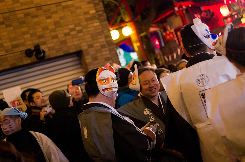 people at a japanese matsuri with fox masks