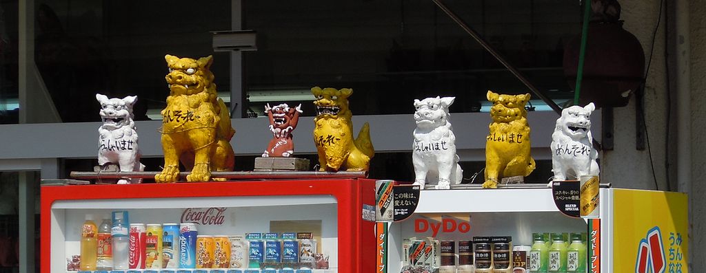 shiisa hanging out on top of vending machines in japan lion dog