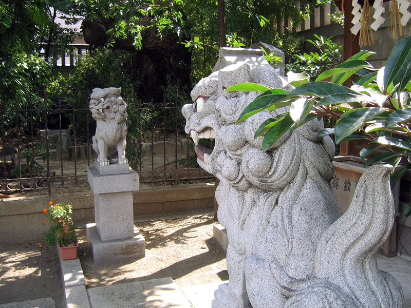 two lion dog statues outside a japanese temple