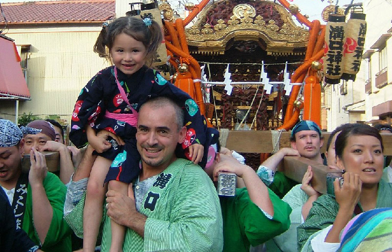 little girl on mans shoulders amidst crowd