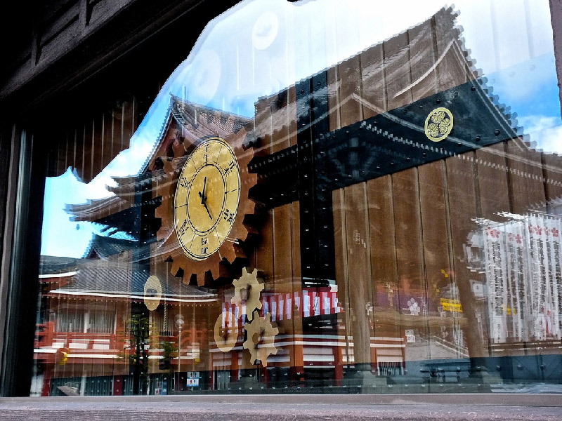 reflection in glass of clock shop