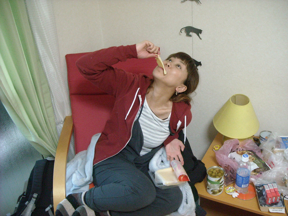 japanese girl putting slice of cheese in her mouth