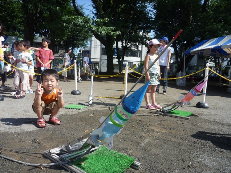 Young boy with a bottle rocket made of recycle materials