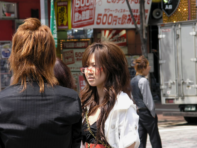 A fashionable gyaru woman with red-framed glasses