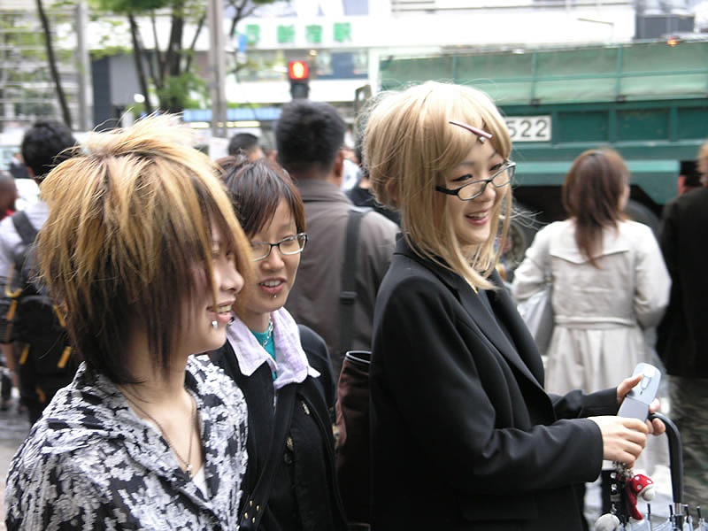 A blond Japanese woman wearing black glasses