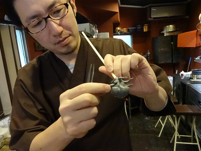 man inspecting candy octopus on a stick