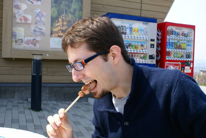man eating food on a stick japanese food