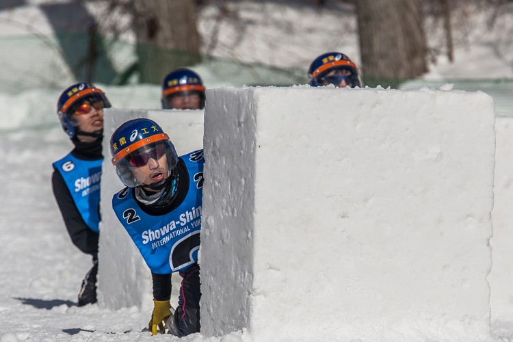 A team of Yukigassen players peeking out from behind cover