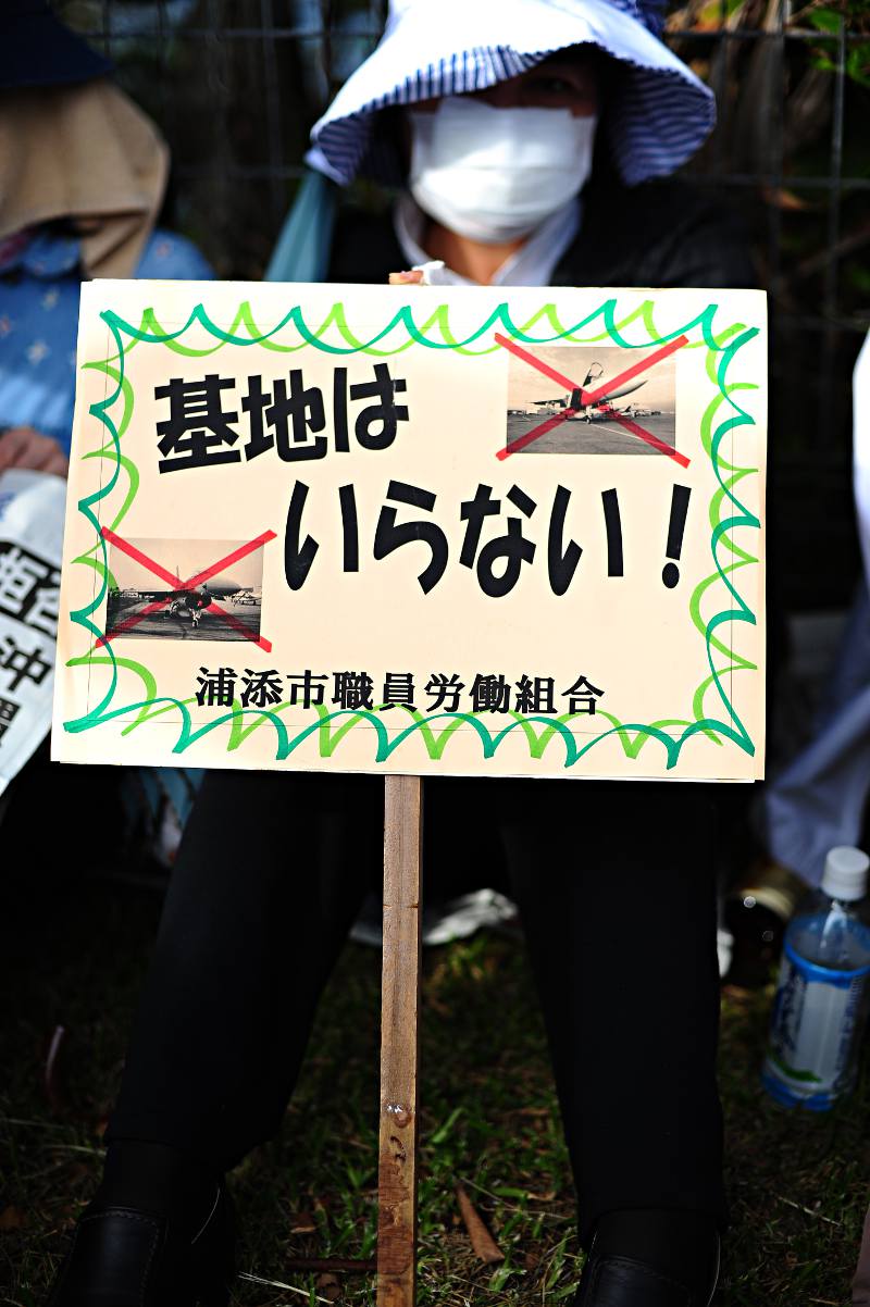 woman holding an anti okinawan base sign