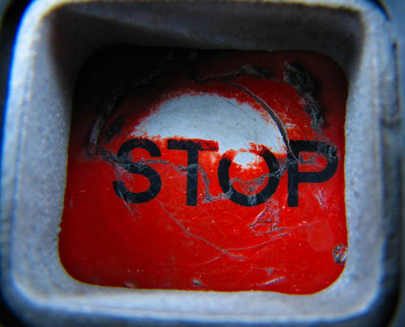 bright red button with the word stop on it