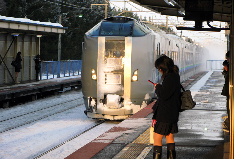 japanese girl at train station on phone in winter