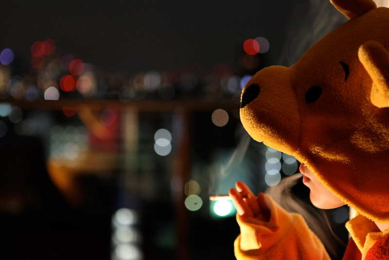 A woman in a Pooh Bear onesie smoking