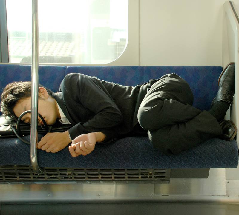 hardworking salaryman in japan sleeping on train seat