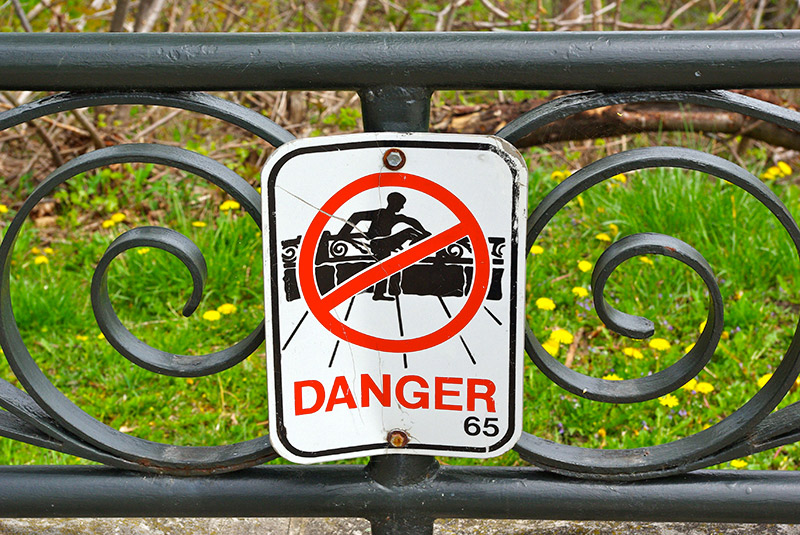 public warning sign attached to guard railing