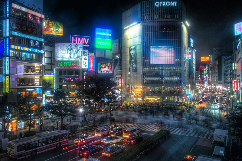 lit up shibuya and billboards intersection in the evening