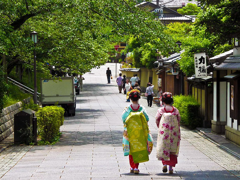 two geisha wearing kimono and walking alone