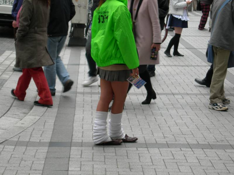 A gyaru woman with very tan legs and slouchy white socks nearly up to her knees