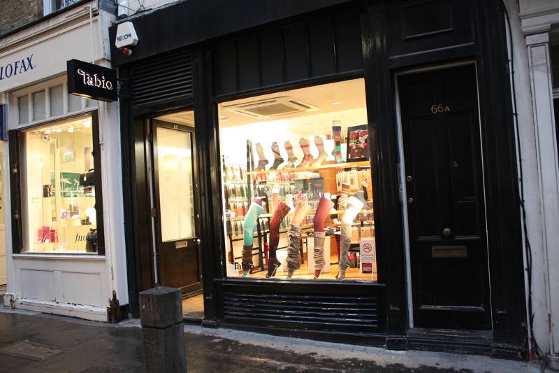 A tabio sock shop window set in a black wood storefront