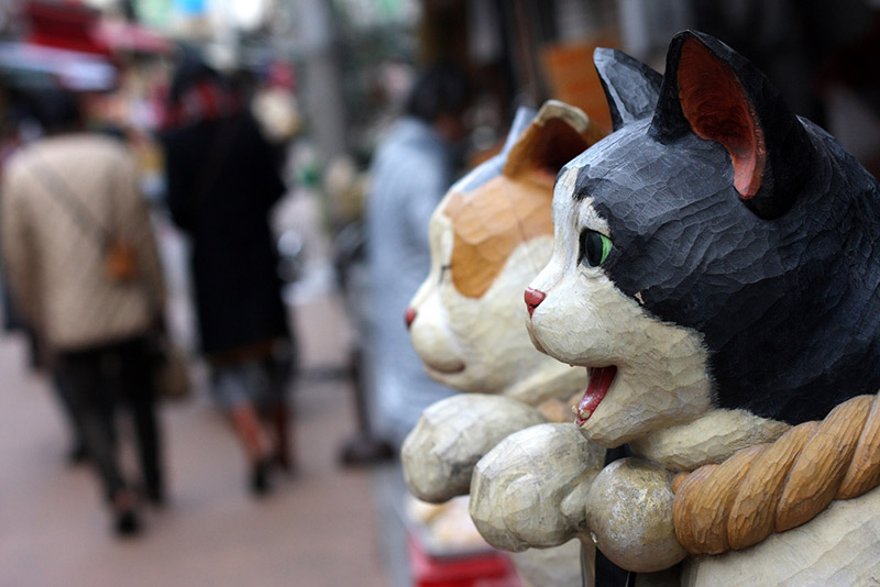 cat sculptures made of wood on a japanese street