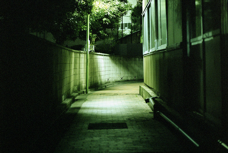 Empty alleyway in Japan illuminated by a single street lamp