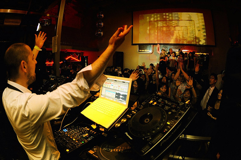 dj gesturing for partygoers to raise their hands