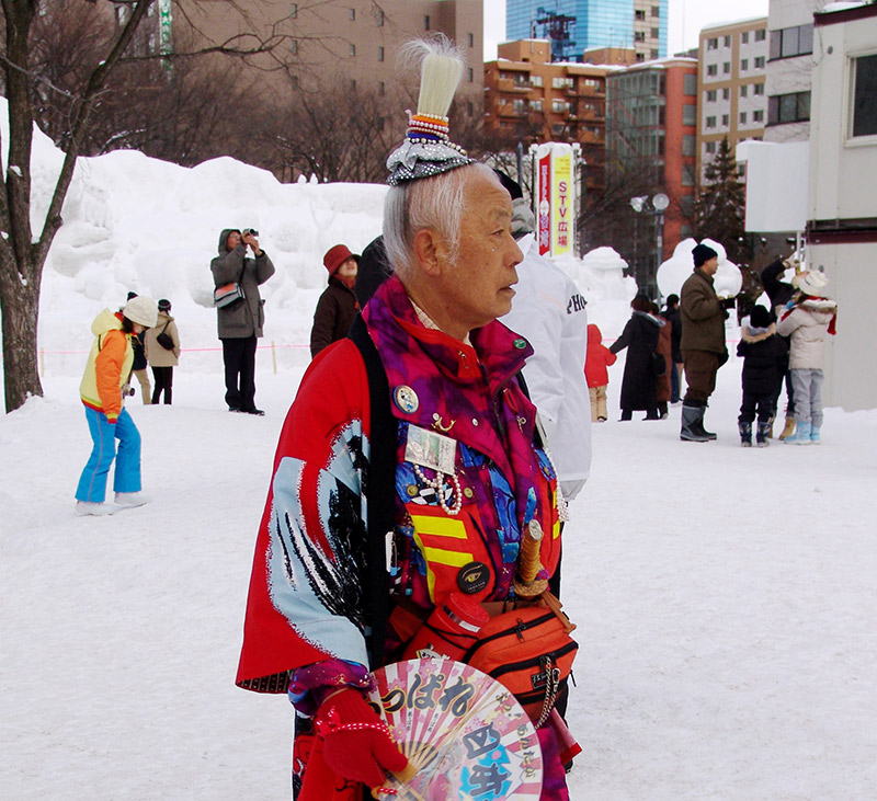 An eccentric Japanese man in colorful pants and jacket