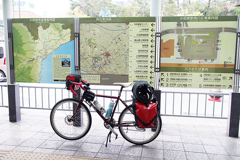 A bicycle in front of bulletin boards with a map