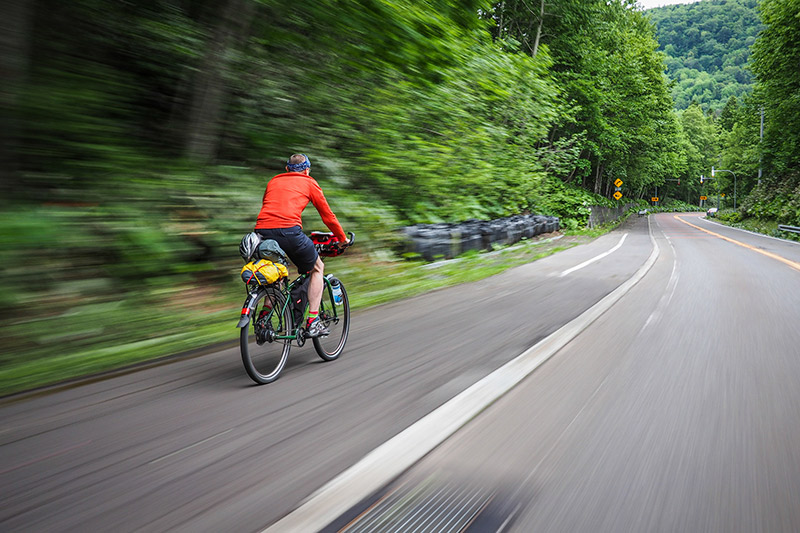 Man on his Japan Cycling Trip speeds down a road