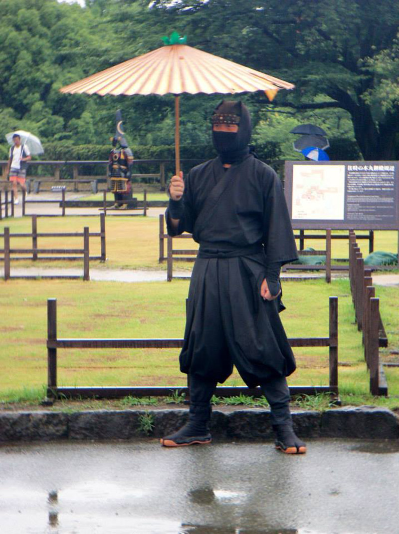 man in ninja costume standing in the rain