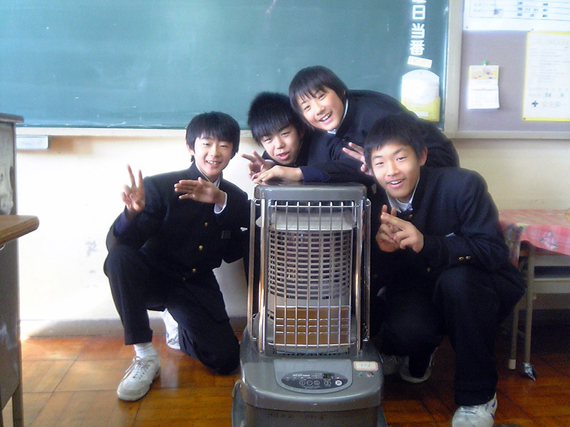 kids in front of a kerosene heater at a Japanese school