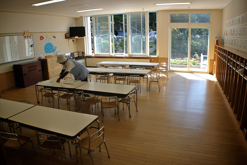 lady cleaning an empty japanese classroom