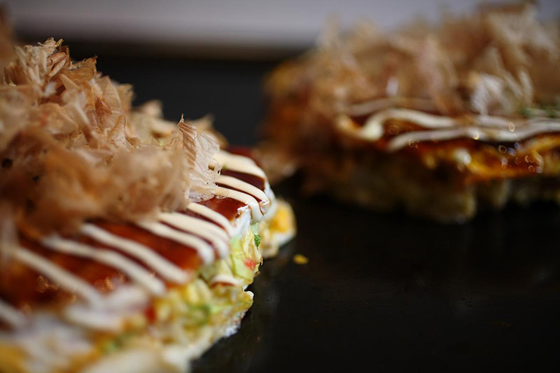 okonomiyaki on the griddle sizzling