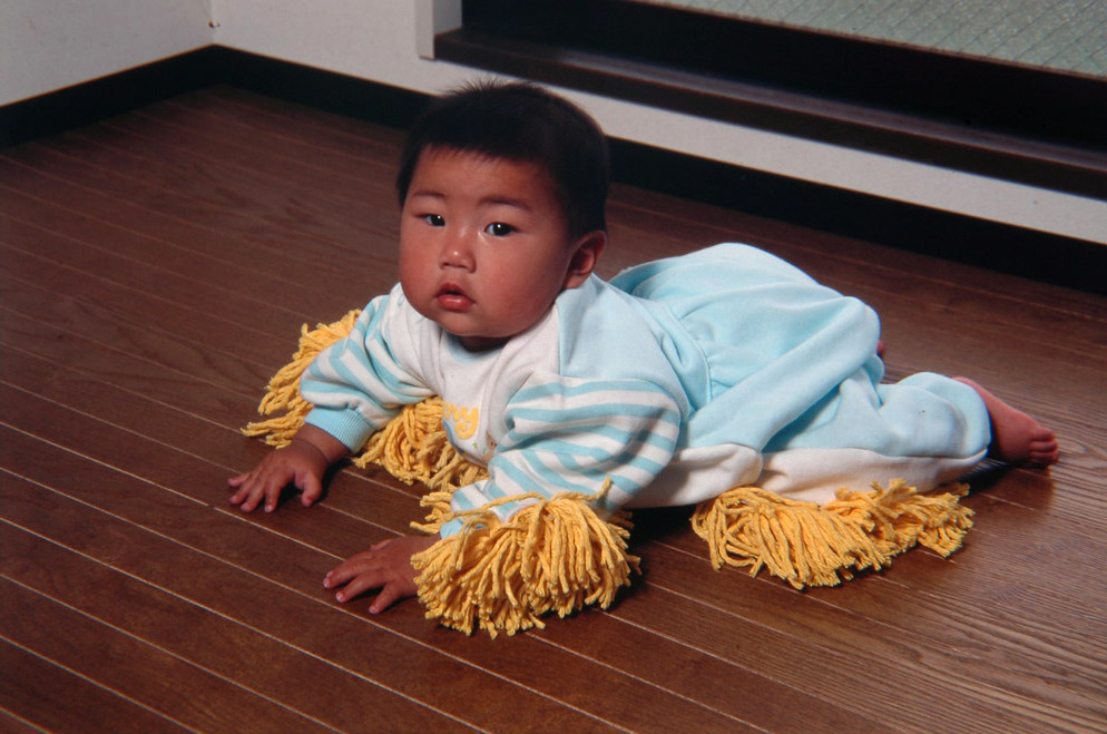 baby wearing suit with mop on it