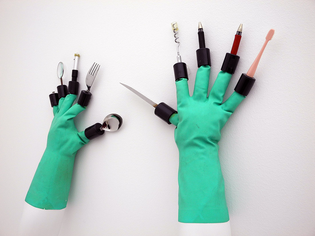 a pair of chindogu gloves with tools on the end of each finger