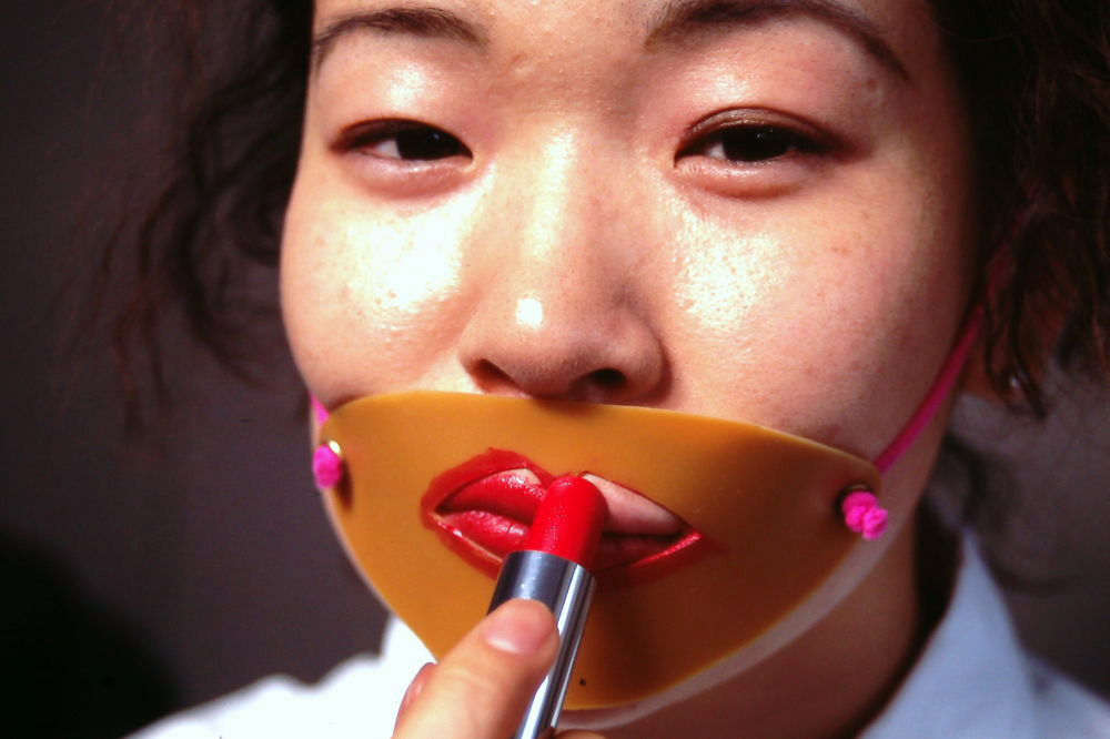 woman applying lipstick with face man-and-woman-using-a-selfie-stick