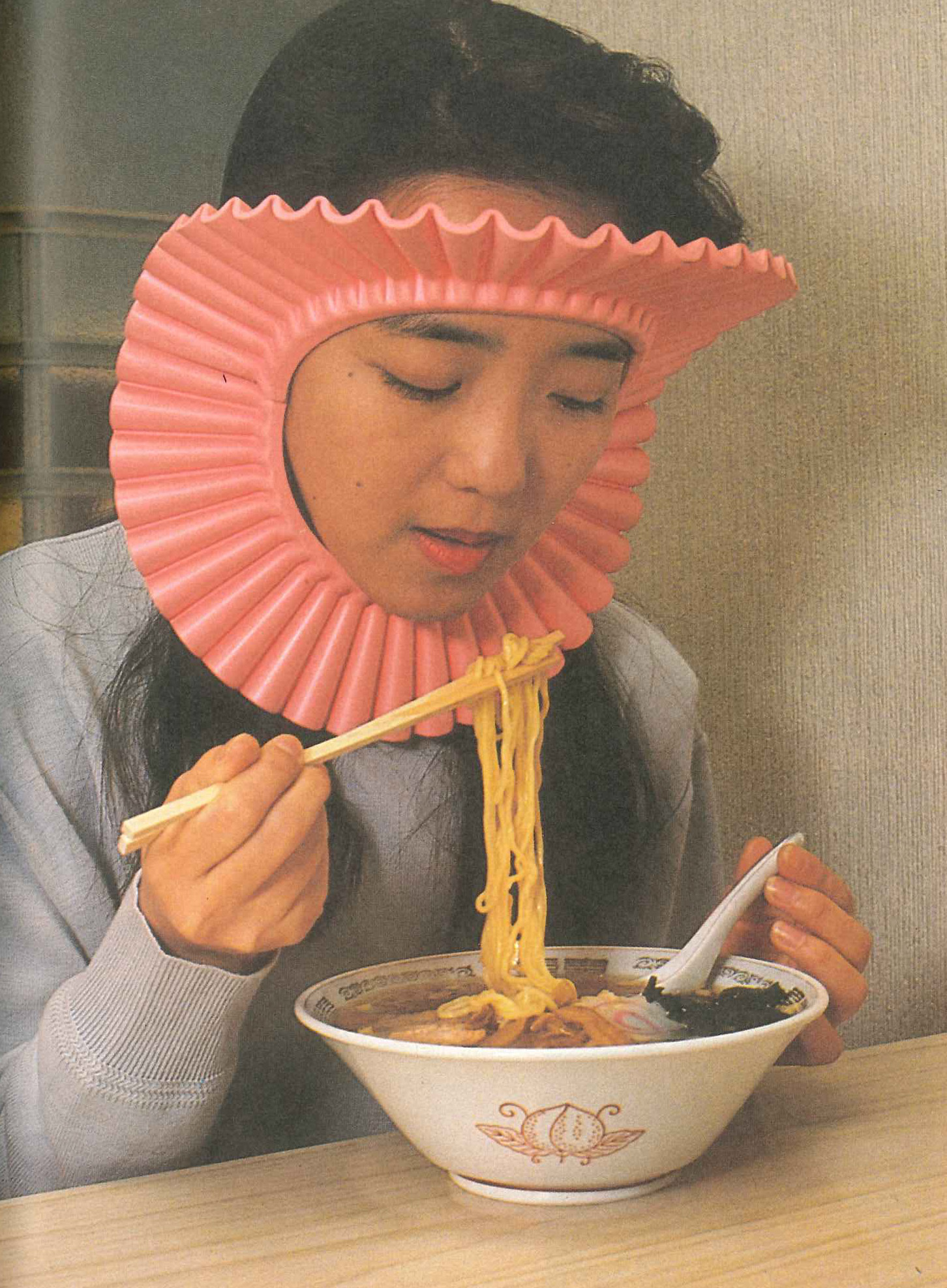 woman eating noodles wearing chindogu