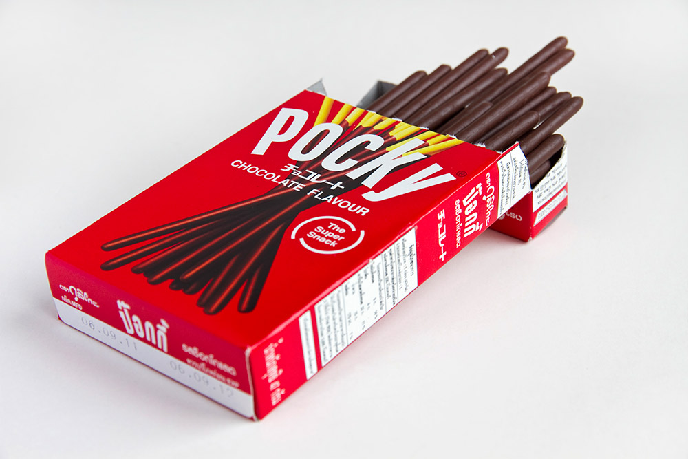 a box of chocolate pocky opened with pocky sticks coming out