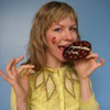 A blond woman eating a cookie